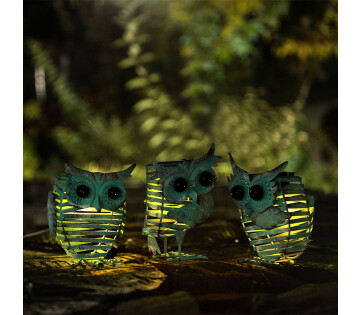 De Set van 3 Hyundai Lighting Solar Tuinlampjes Vintage Owl staat buiten in het donker. 