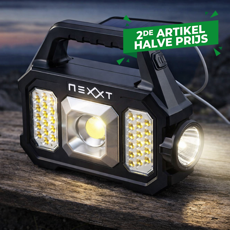 De Nexxt Solar Noodlamp en Powerbank staat buiten.