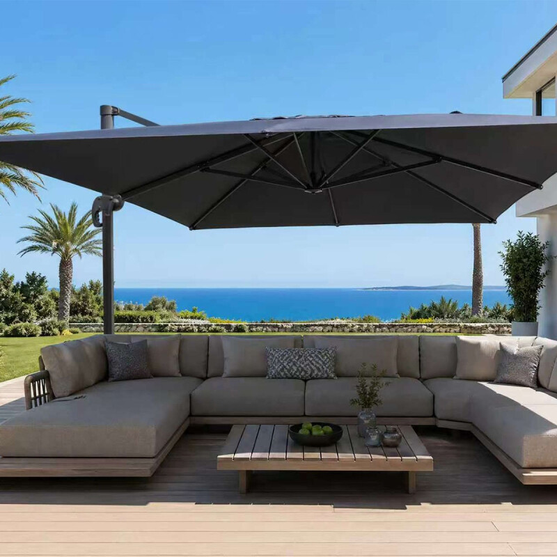 Luxe zweefparasol Roma 4x3 meter in donkergrijs boven moderne loungeset met zeezicht