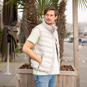 Een man draagt de Mario Russo bodywarmer in de kleur beige, de bodywarmer is verkrijgbaar in crème en marineblauw. 
