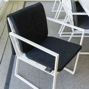 De Warmigo Dual Heatzone Draadloze Stoelverwarming ligt over een tuinstoel. 