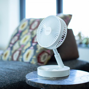 De ventilator staat op een bijzettafeltje. 