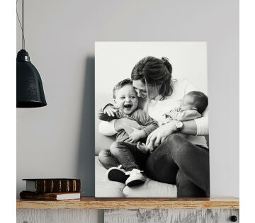 Een canvas heeft een foto van een moeder en haar 2 kinderen er op gedrukt. Een canvas heeft een foto van een moeder en haar 2 kinderen er op gedrukt.