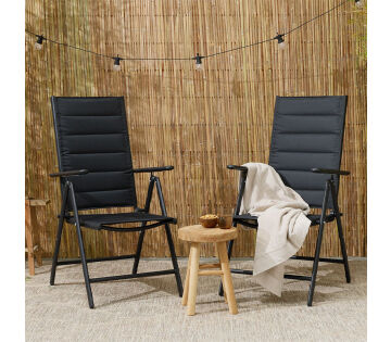 De Premium Tuinstoelen met Padding staan op een terras. Links staat de zwarte variant en rechts de antraciet. 