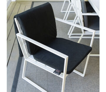 De Warmigo Dual Heatzone Draadloze Stoelverwarming ligt over een tuinstoel. 