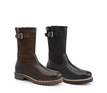 Bruine en zwarte Travelin’ leren laarzen met gesp en wolvoering naast elkaar