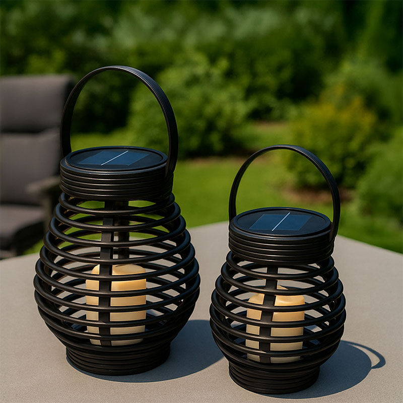 Twee FlinQ Solar Lantaarns Bottassano in rotan stijl met warm LED-licht, geplaatst op een tafel in de tuin. Twee FlinQ Solar Lantaarns Bottassano in rotan stijl met warm LED-licht, geplaatst op een tafel in de tuin.