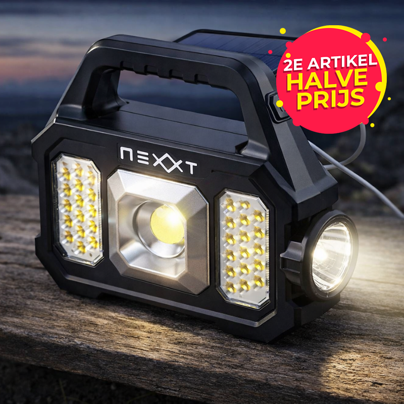De Nexxt Solar Noodlamp en Powerbank staat buiten.